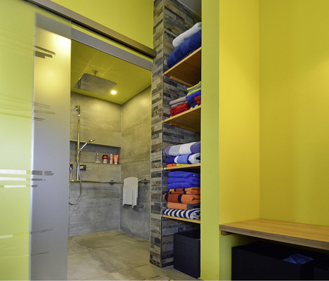 
Die Dusche ist durch eine satinierte Schiebetür einfach zugänglich, neben dem Handtuch-Regal wurde eine Sitzgelegenheit integriert. 



