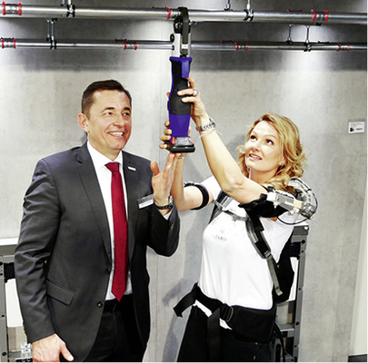 
Bad-Botschafterin mit Exoskelett: Franziska van Almsick testet, wie Über-Kopf-Arbeit durch technische Assistenz mittels Korsett funktioniert.



