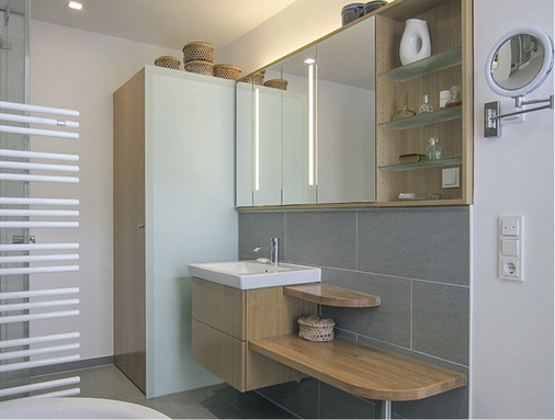 
Unter dem Waschtisch schafft ein Unterschrank Stauraum. Daran schließt sich eine Bank aus geöltem Eichenholz an.



