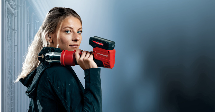 Um einen themenrelevanten Alt-Text für das Bild zu erstellen, sollte der Fokus auf relevante Details und den spezifischen Kontext der Fachzeitschrift gelegt werden. Hier ist ein optimierter Alt-Text: „Technikerin in Arbeitskleidung demonstriert die Anwendung eines roten Rohrschneiders vor einer industriellen Kulisse zur Installation von Heizungsrohren. - © ROTHENBERGER Um einen themenrelevanten Alt-Text für das Bild zu erstellen, sollte der Fokus auf relevante Details und den spezifischen Kontext der Fachzeitschrift gelegt werden. Hier ist ein optimierter Alt-Text: „Technikerin in Arbeitskleidung demonstriert die Anwendung eines roten Rohrschneiders vor einer industriellen Kulisse zur Installation von Heizungsrohren. - © ROTHENBERGER