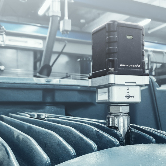 Zwischen den Kühlrippen eines Motors eingeklebter „Grundfos Machine Health“-Sensor. Ein in der Nähe installierter Sender leitet die Daten mehrerer Sensoren über eine Cloud-Anwendung zur Auswertung weiter.