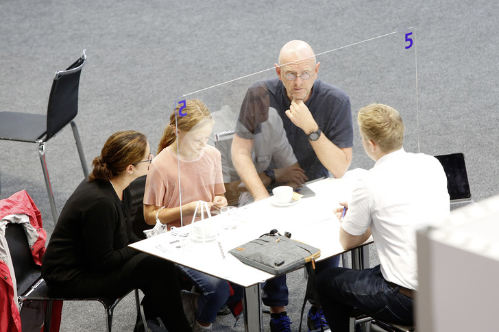 Gesprächsbedarf oder Kaufabschluss: An den Besprechungsinseln der Aussteller klappte die Verständigung trotz Glasscheibe. - © Bild: Messe Düsseldorf/C.Tillmann
