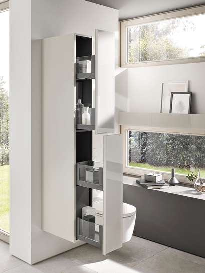 Ein Hochschrank mit Apothekerauszug bringt Struktur ins Bad und eignet sich ideal als Raumtrenner. Dank lackierter Oberfläche ist er robust und lässt sich leicht abwischen.