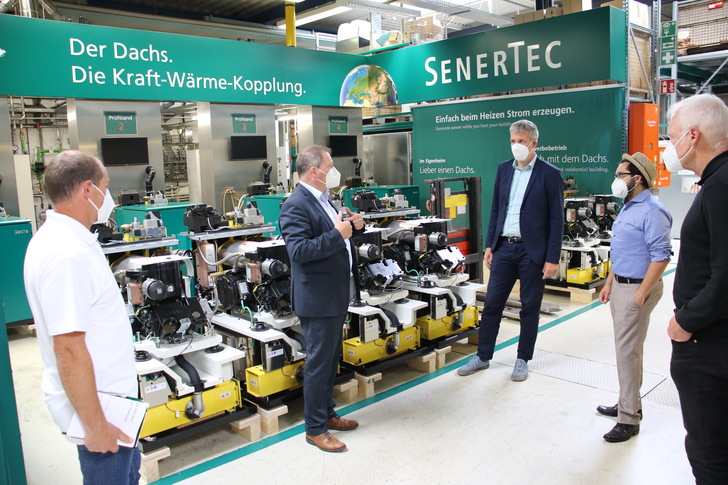 Stadtrat Dr. Reginhard von Hirschhausen, Grünen-Obmann Nicolas Lommatzsch und der Bundestagsabgeordnete der Grünen, Dieter Janecek (v.r.), lassen sich von Hagen Fuhl (Prokurist und Leiter Normungs- und Öffentlichkeitsarbeit/ Public Affairs bei SenerTec 2.v.l.) sowie Andre Merz (Referent für Energierecht l.) die Technik des Dachs erklären.