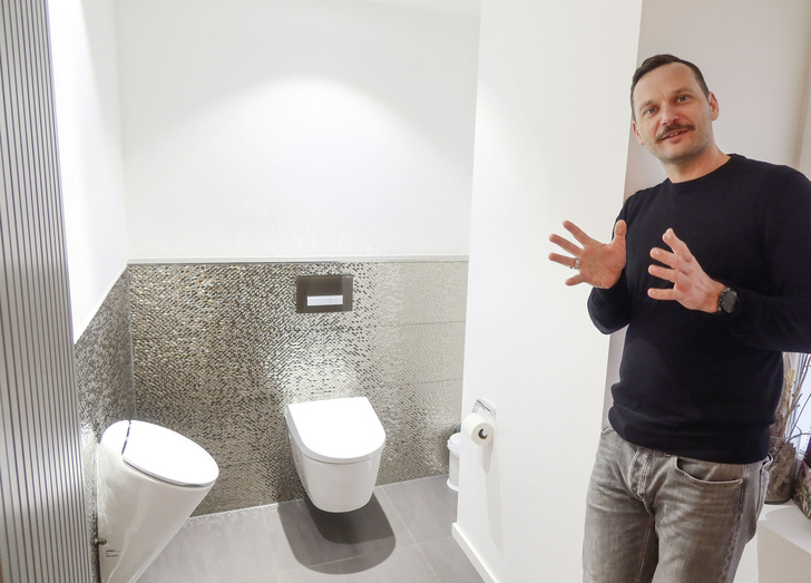 Die Kundentoilette nutzt Alexander Fritz, um Dusch-WCs zu erklären. Interessierte dürfen gerne in aller Ruhe Probe sitzen. - © Bild: Jäger / SBZ
