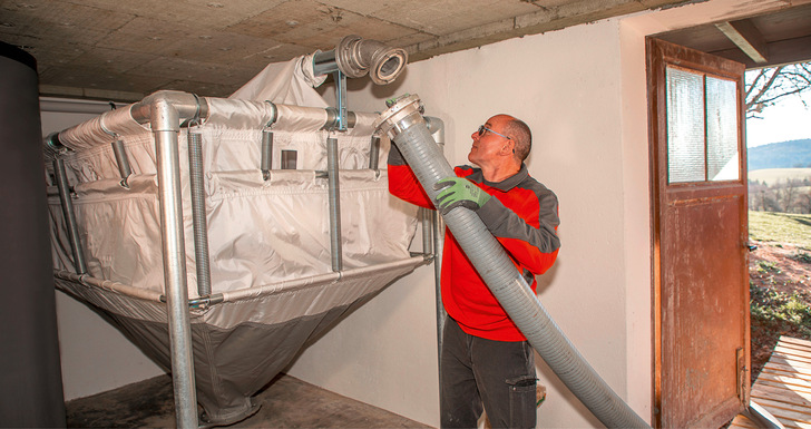 Zum Einblasen der Pellets ins Lager befestigt der Lieferant einen Schlauch am Sacksilo. - © Bild: Depi