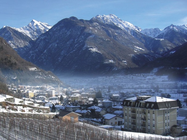 Sichtbar hohe Feinstaubbelastung aus Holzfeuerungen und Straßenverkehr statt gesunder Bergluft (Blick auf den unteren Taleingang des Misox)