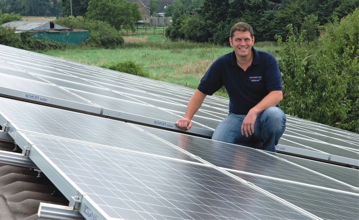 Installateur Bob Troescher zwischen den Solarmodulen auf dem Dach seines Kunden in Erftstadt.