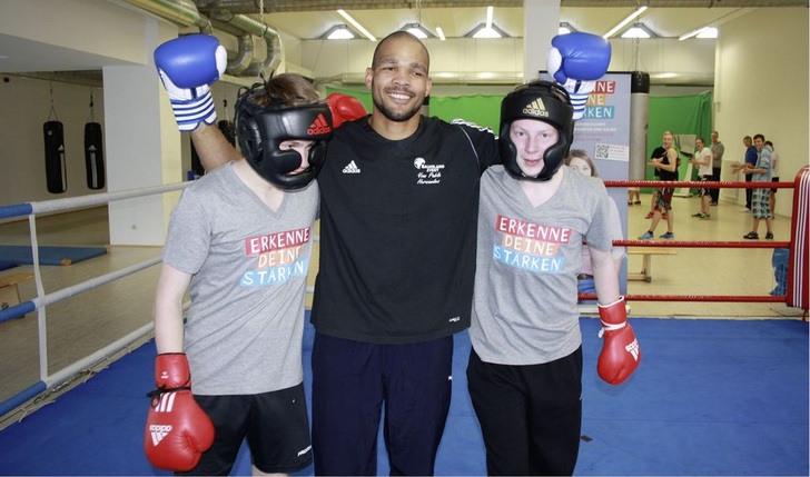 Weltmeister Yoan Pablo Hernández im Boxring mit den beiden zukünftigen Auszubildenden von HSW, Hans-Peter Freudiger und Felix Schössow.