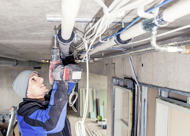 <p>Verlegung von kunststoffummanteltem C-Stahl-Rohr für ein Heiz- und Kühlsystem im Deckenbereich einer Montagehalle.</p> - © Geberit / www.FlorianGerla.ch