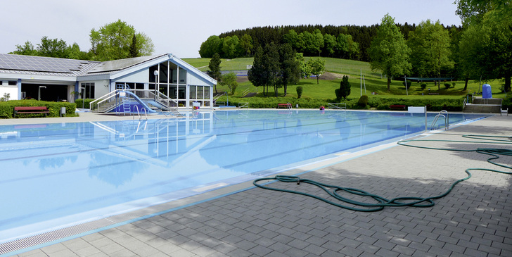 
Da es auf dem Dach bereits eine PV-Anlage gab, hat eine Gemeinde im Landkreis Passau eine solare Beckenwasserheizung auf ebener Erde (hinter der Baumgruppe) errichtet.
