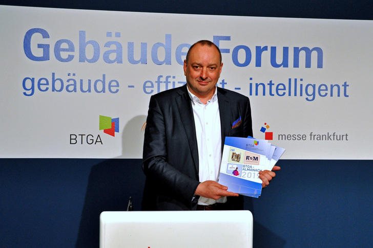 BTGA-Präsident Hermann Sperber präsentiert den druckfrischen BTGA-Almanach auf der ISH 2019. - © ja / BTGA e.V.
