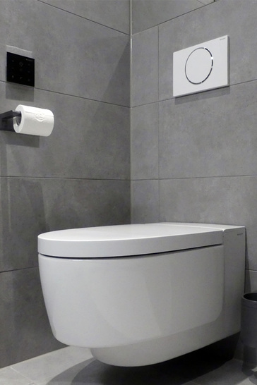 Das Dusch-WC Geberit AquaClean Mera fügt sich mit seiner schlichten Formensprache elegant in das Hotelbad ein. Bedienen lassen sich die Komfort-Funktionen über ein praktisches Wandbedien-Panel