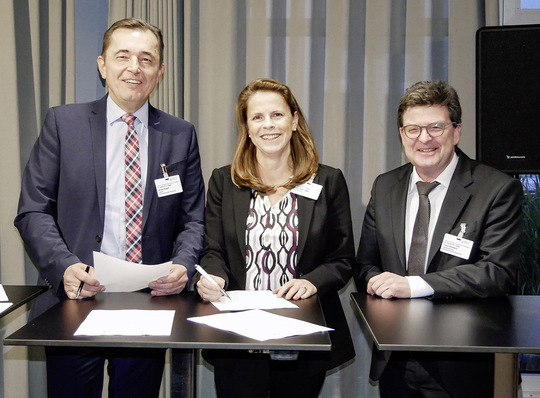 Christin Roth-Jäger, Geschäftsführerin der Roth Werke, unterzeichnet im Beisein von ZVSHK-Präsident Michael Hilpert (links) und Hauptgeschäftsführer Helmut Bramann die HÜV 2.0 des ZVSHK.