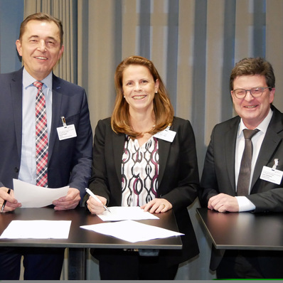 Christin Roth-Jäger, Geschäftsführerin der Roth Werke, unterzeichnet im Beisein von ZVSHK-Präsident Michael Hilpert (links) und Hauptgeschäftsführer Helmut Bramann die HÜV 2.0 des ZVSHK.