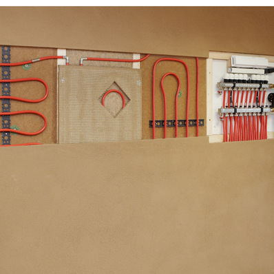 Funktionsfähige Musterfläche einer Wandheizung in der Ausstellung eines Handwerkbetriebs in Nass- und Trockenbauweise mit sämtlichen Komponenten, einschließlich der Wärmeverteilschicht aus Lehmputz.