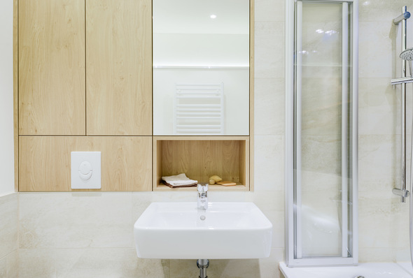 Der Waschplatz wird gestalterisch betont: Ablage und Spiegel greifen die Breite des Beckens auf.