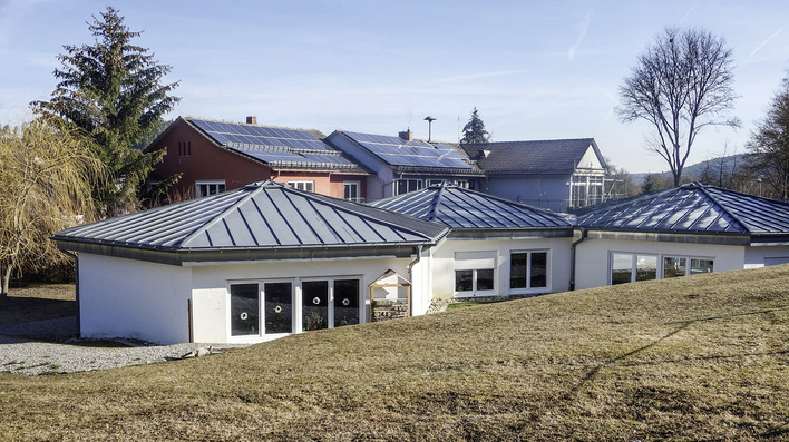 Schlossberghalle Niedereschach, Schwarzwald-Baar-Kreis: Eine Gruppe eng zusammenstehender Gebäude wird von einer Heizzentrale mit Wärme versorgt. Die alte Ölheizung wurde durch ein bivalentes Holzpellet-Gas-Brennwert-Heizsystem ersetzt.