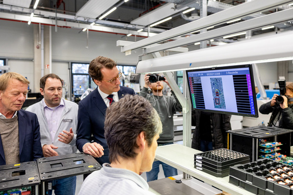 NRW-Ministerpräsident Hendrik Wüst (Mitte) und der Remscheider Oberbürgermeister Burkhard Mast-Weisz (links) auf einem Rundgang durch die neue Vaillant Group Elektronikfabrik.