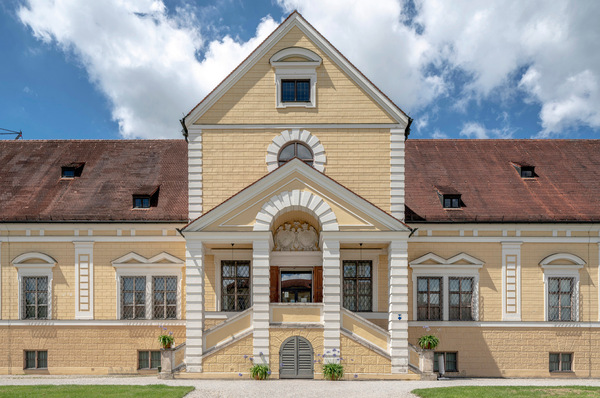 Alt-Text: „Modernes Heizungs- und Klimaanlagensystem, integriert in ein saniertes historisches Gebäude mit energiesparenden Lösungen, unter einem klaren blauen Himmel.“. - © Bild: Zehnder Group Deutschland GmbH