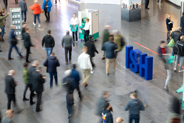 Besucher einer Branchenfachmesse für Sanitär-, Heizungs- und Klimatechnik in einer großen Messehalle mit prominentem ISH-Logo rechts im Bild, die neuesten Innovationen und Technologien der SHK-Branche präsentiert. - © Messe Frankfurt Exhibition GmbH / Jochen Günther