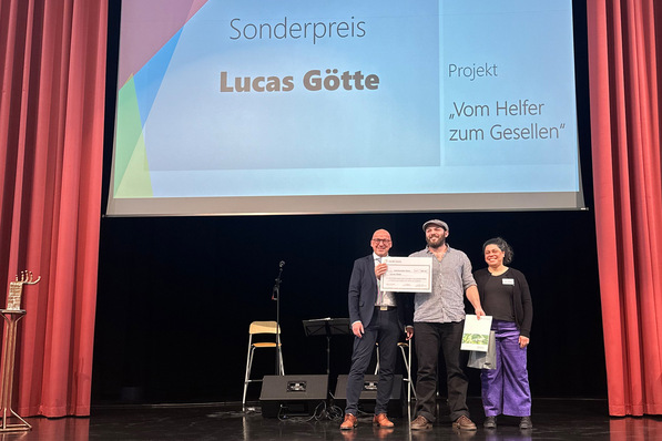Gerne! Hier ist ein optimierter, themenrelevanter Alternativtext, der die Anforderungen an Barrierefreiheit und Zielgruppenansprache im Kontext eines SHK-Fachverlags erfüllt: Alt-Text: „Drei Fachleute aus der Sanitär-, Heizungs- und Klimatechnik-Branche erhalten auf einer Bühne den Sonderpreis ‚Lucas Götte‘ für innovative Lösungen; im Hintergrund informiert eine Leinwand über die Auszeichnung.“. - © Innung SHK Berlin