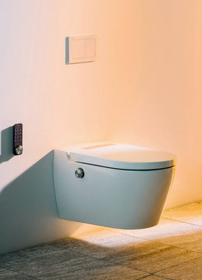 "Moderne wandhängende Toilette mit spülrandloser Keramik in einem Badezimmer mit beige gefliesten Wänden und Boden; Beispiel für hygienische Sanitärinstallation und barrierearme Badgestaltung gemäß aktuellen Branchenstandards. - © Bild: Laufen