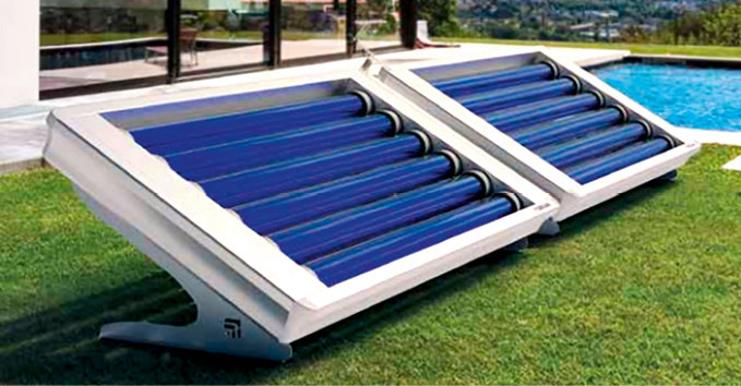 Zwei Solar-Poolheizungen mit blauen Röhren sitzen auf dem Rasen neben einem Pool in einem modernen Garten. - © Bild: Cordivari