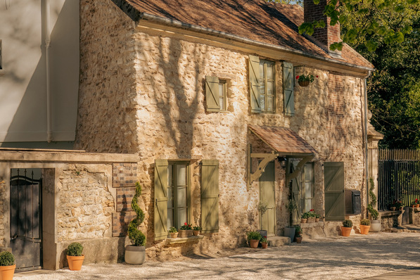 Historisches Entrée: Naturstein, salbeigrüne Fensterläden und ein Ziegeldach prägen das mehr als 400 Jahre alte Torhaus. Das behutsam sanierte Gebäude steht am Eingang eines Schlossgeländes nahe Paris.