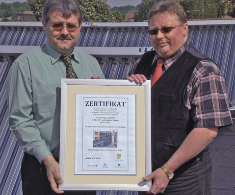 Solare Großanlage im Seniorenpflegeheim: Übergabe eines werbewirksamen „Klimaschutz-Zertifikats“ an den Betreiber durch Christoph Ehlers (l.). Auf dem Zertifikat wird die jährliche Einsparung von 7,75 t CO2 und von 3909 m³ Erdgas durch die ­installierte Anlage hervorgehoben